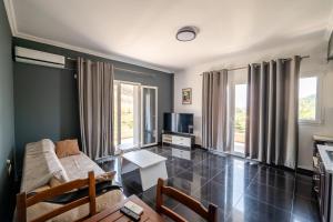 a living room with a couch and a tv at Vila Andrea in Himare
