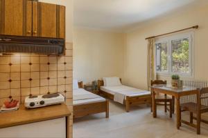 a small room with two beds and a table at Kallithea Studios & Apartments in Lakíthra