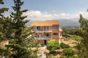 a house on top of a hill with trees at Kallithea Studios & Apartments in Lakíthra