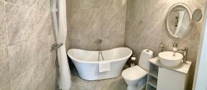 ein Badezimmer mit Badewanne, Toilette und Waschbecken in der Unterkunft Villa Evalotta in Fjällbacka + 60 Fotos