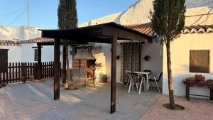 a patio with an awning and a table and a grill at Cuevas Padre Poveda in Guadix