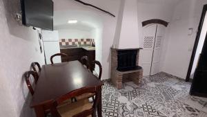 a kitchen with a wooden table and a stove at Cuevas Padre Poveda in Guadix