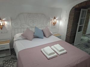 a bedroom with a large bed with two towels on it at Cuevas Padre Poveda in Guadix +26 photos