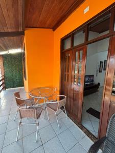 a patio with a glass table and chairs on a porch at Casa Fácil in Itacaré