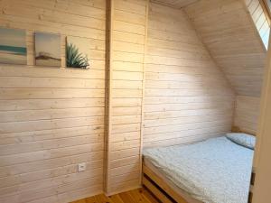 a small wooden cabin with a bed in it at BalticMoon Rewal Domki z Podgrzewanym Basenem in Rewal +22 photos