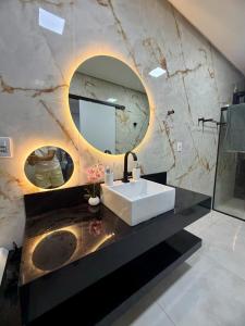 a bathroom with a sink and a mirror at Casa estadia Capitólio in Capitólio +38 photos