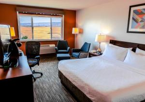 a hotel room with a bed and chairs and a window at Holiday Inn Express Pendleton by IHG in Pendleton +15 photos
