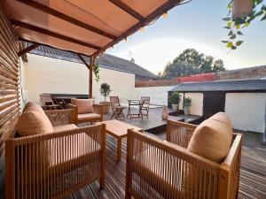 a patio with chairs and tables on a wooden deck at Maisons Sauvage 3 3 Bis in Romorantin