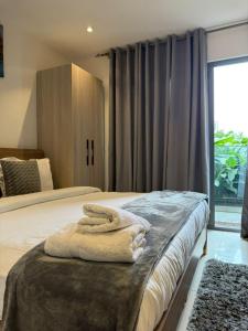 a bedroom with a bed with two towels on it at The Snug Stay - Lennox in Accra