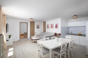a kitchen and living room with a white table and chairs at Pula Istria Apartments in Pula
