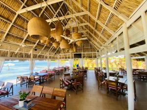 a restaurant with tables and chairs and a large ceiling at Las Palmas Beach Roatan in Dixon Cove