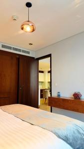 a bedroom with a bed and a dresser and a mirror at Millennium Private Apartment in Salalah
