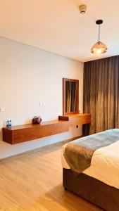 a bedroom with a bed and a mirror in it at Millennium Private Apartment in Salalah