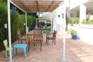 a patio with chairs and a table with a wooden roof at Residence Le Barchette in San Cataldo