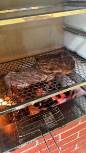 two pieces of meat cooking on a grill at Sítio de Vavá in Gravatá