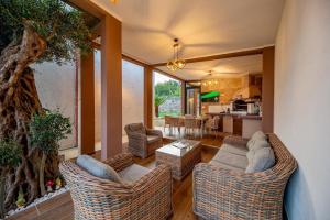 a living room with wicker furniture and a kitchen at Guest House Luksic in Bar