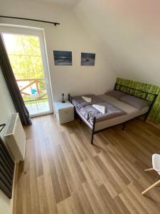 a bedroom with a bed and a large window at House Hostelli in Grzybowo