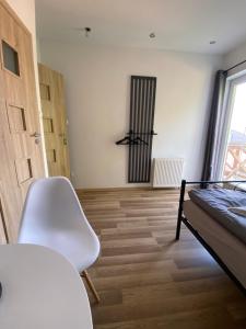 a room with a bed and a chair and a table at House Hostelli in Grzybowo