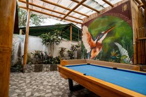 a pool table in a room with a painting on the wall at Mindo GlamBird Glamping & Lodge in Mindo