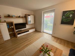 an empty living room with a table and a tv at Ferienwohnung mit Salzachblick in Laufen