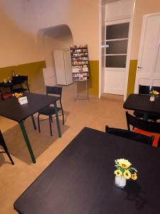 a room with two tables and chairs with flowers on them at Parvis Magna Hostal in Guaymallen
