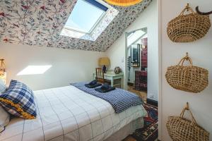a bedroom with a bed with baskets on the ceiling at La Maison dAmbre-Jacuzzi-Sauna-Clim-4chambres in Saumur +70 photos