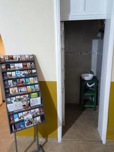 a room with a shelf with books and a sink at Parvis Magna Hostal in Guaymallen