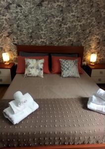a bedroom with a bed with towels and pillows at Collina Blu in Cuglieri