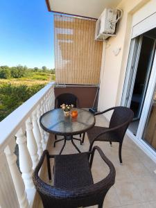 a patio with a table and chairs on a balcony at JONNY'S Rooms in Paralia Katerinis