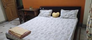 a bed with two pillows and a table with a bedspread at Nilayam guest house in Patna
