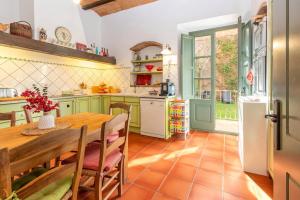 a kitchen with green cabinets and a wooden table at Centro Palafrugell: Casa con Piscina y Solárium in Palafrugell