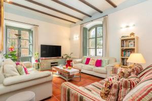 a living room with two couches and a tv at Centro Palafrugell: Casa con Piscina y Solárium in Palafrugell