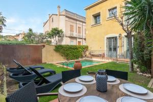 a patio with a table and chairs and a pool at Centro Palafrugell: Casa con Piscina y Solárium in Palafrugell