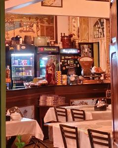 a restaurant with tables and chairs and a refrigerator at Pousada e Restaurante Dona Siroba in Morretes