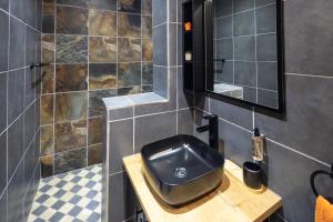 a bathroom with a black sink and a mirror at Fox Inn Guesthouse Lephalale in Lephalale +29 photos
