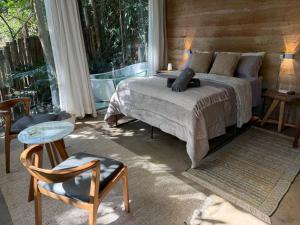 a bedroom with a bed and a table and a chair at Casa Aquário in Petrópolis