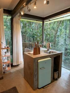 a kitchen with a counter with a sink and a window at Casa Aquário in Petrópolis