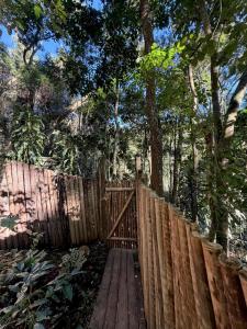 a wooden fence with a wooden gate in a forest at Casa Aquário in Petrópolis +16 photos