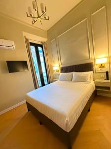 a bedroom with a large white bed with a chandelier at Malaga Rooms in Málaga