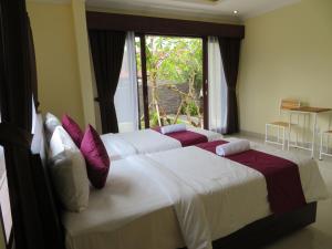 2 letti in una camera da letto con finestra di Odah Ayu Guest House ad Ubud Altre 37 foto