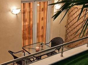 a glass table and chairs on a balcony at JONNY'S Rooms in Paralia Katerinis +24 photos
