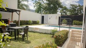 a backyard with a table and chairs and a pool at Villas del Guali - Piscina Privada in Santa Fe de Antioquia