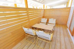 a room with a table and chairs on a wooden floor at ヌックベル in Kumamoto