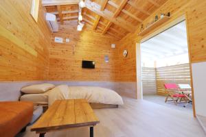 a room with a bed and a table in it at ヌックベル in Kumamoto