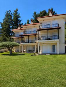 a large building with a grassy yard in front of it at E&M Villa Sea View II in Polychrono
