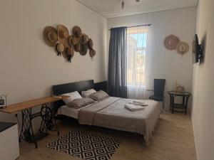 a bedroom with a bed and a window with hats on the wall at Belle Art Hotel in Odesa