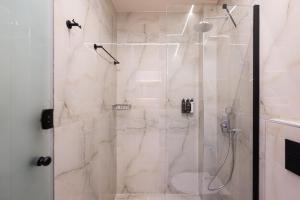 a bathroom with a shower with a glass door at ZOI Girni - Seaside Hotel in Olympic Beach +23 photos