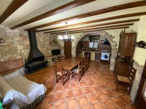 a living room with a table and a fireplace at Masía de piedra con piscina in Riudecols