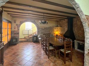 a dining room with a table and a stone wall at Masía de piedra con piscina in Riudecols