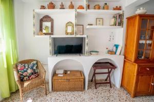 a living room with a tv and a chair and a table at House Los Angeles in Chulilla